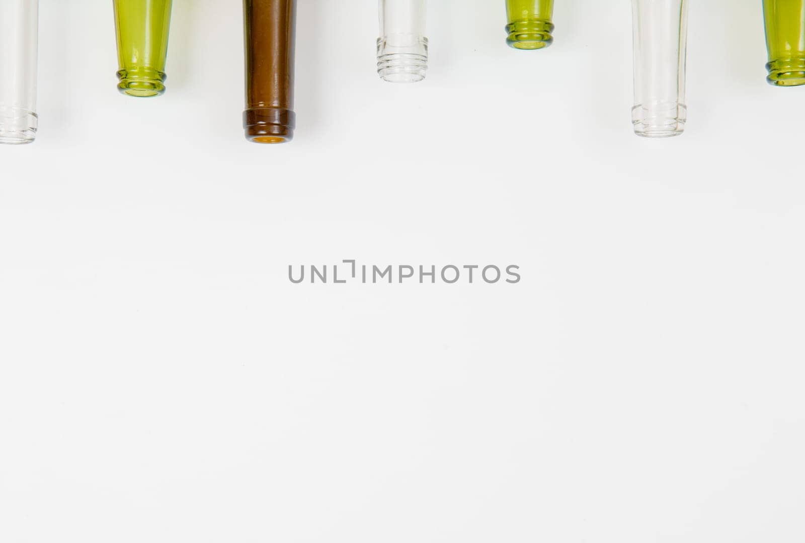 Empty glass bottles of mixed colors including green, clear white, brown