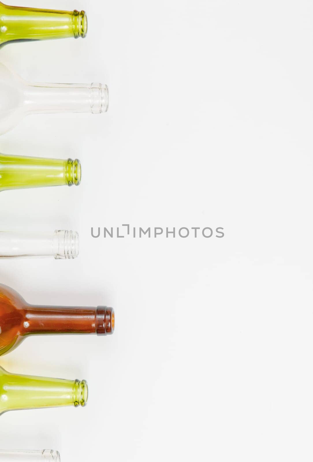 Empty glass bottles of mixed colors including green, clear white, brown