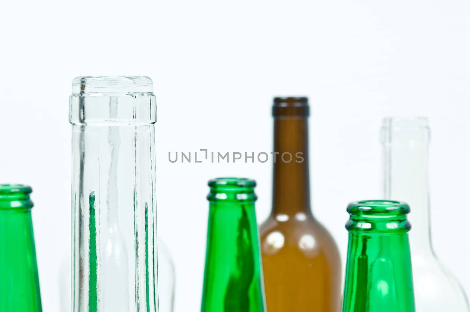 Empty glass bottles of mixed colors including green, clear white, brown