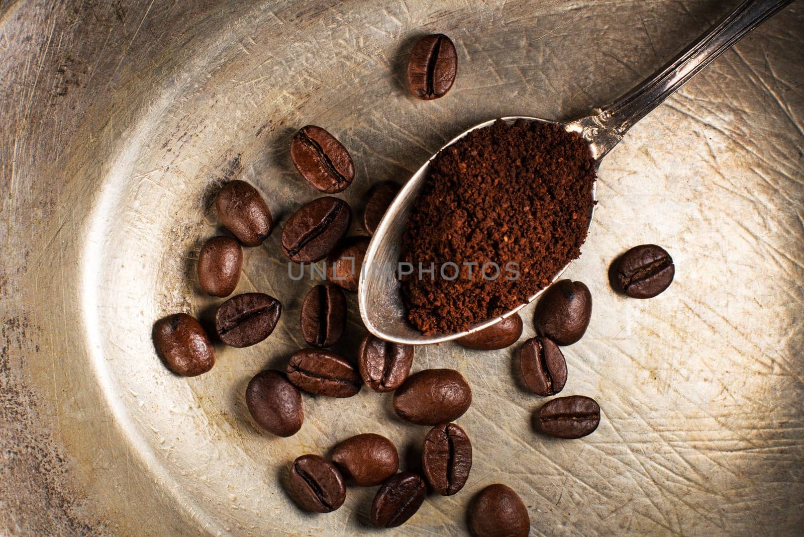 Fresh ground Coffee in spoon on plate close up.