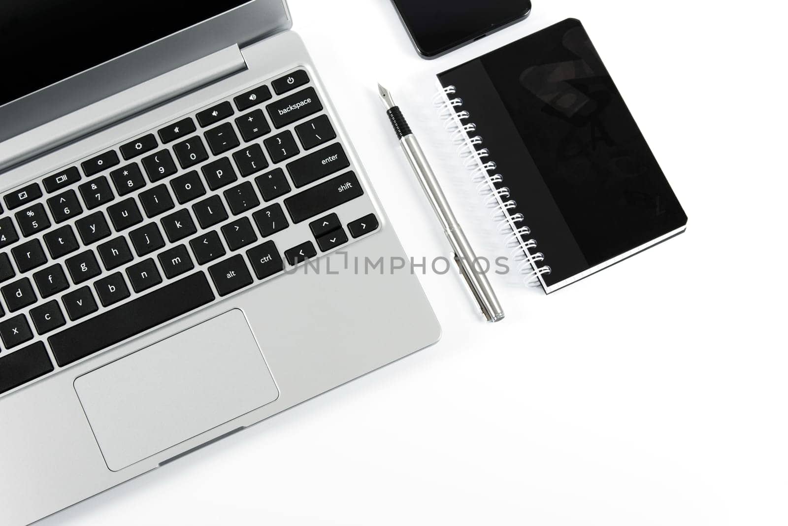 Elegant laptop and pen with notebook isolated on white background