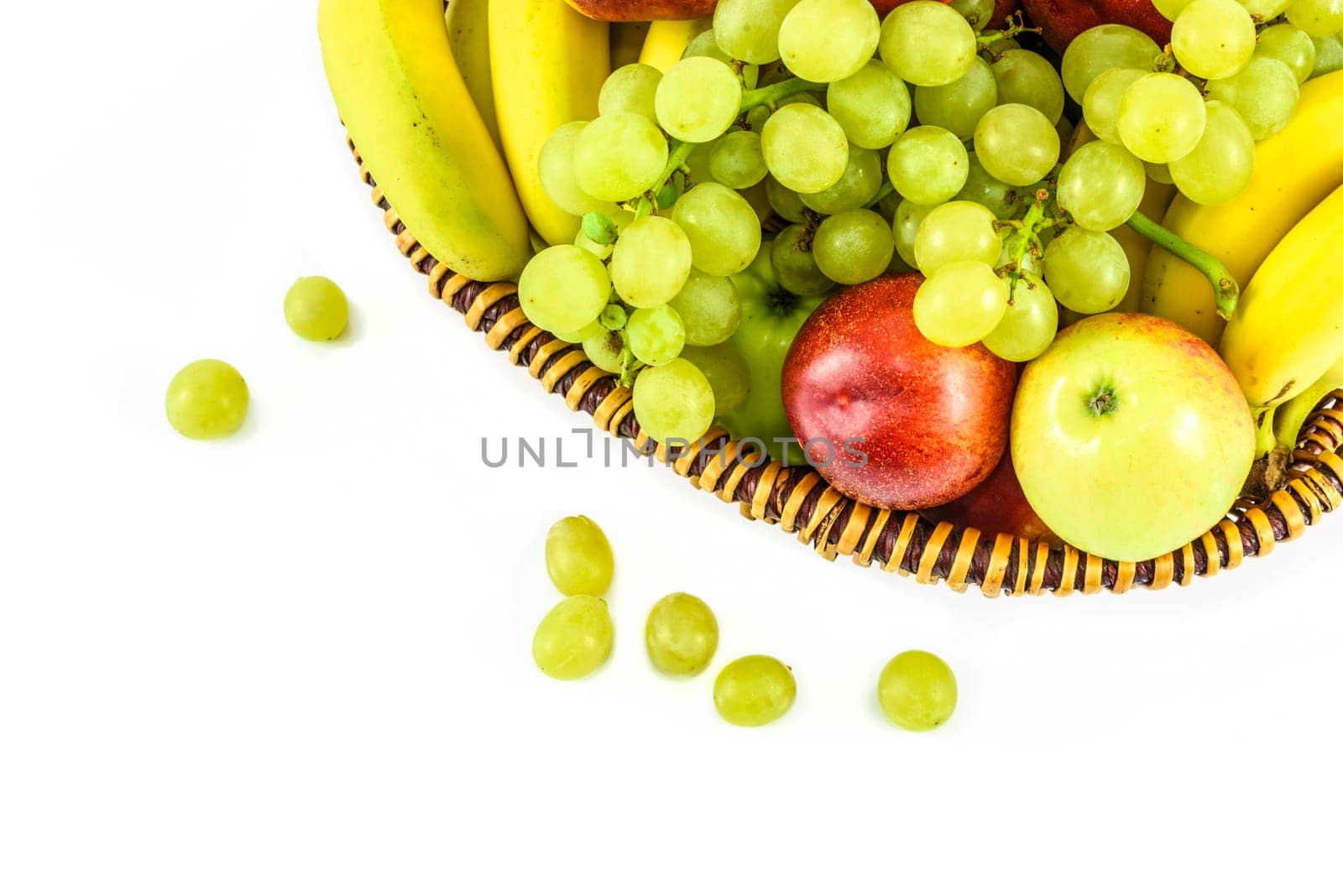 Overhead shot of the basket full of fruit and scattered grapes