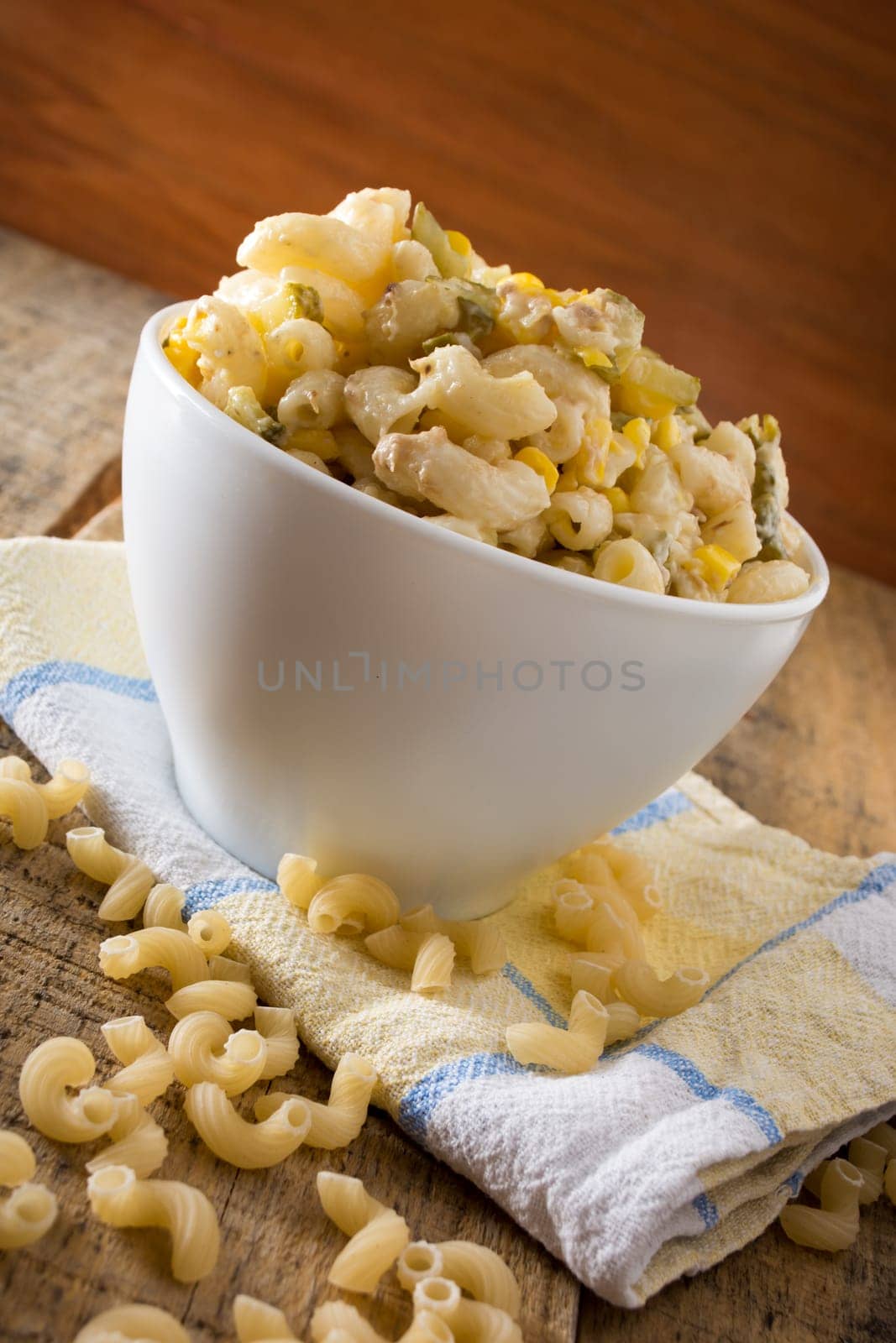 Close up of a salad with pasta, yellow corn and Italian seasonings.