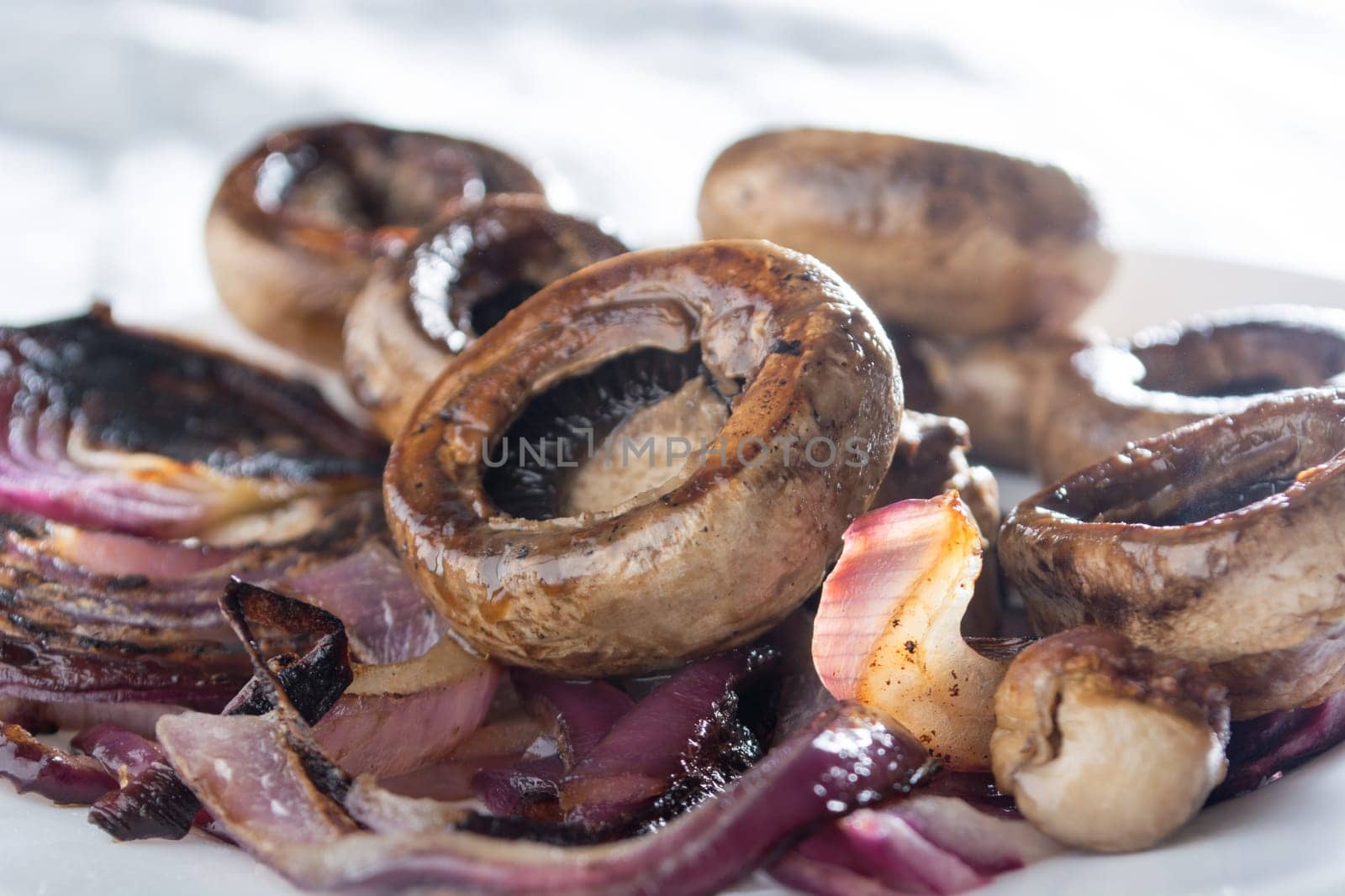 Roasted mushrooms with onion on white plate