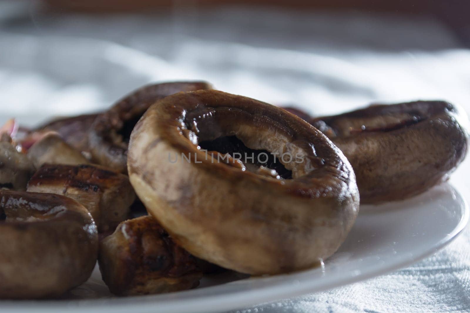 Roasted mushrooms with onion on white plate