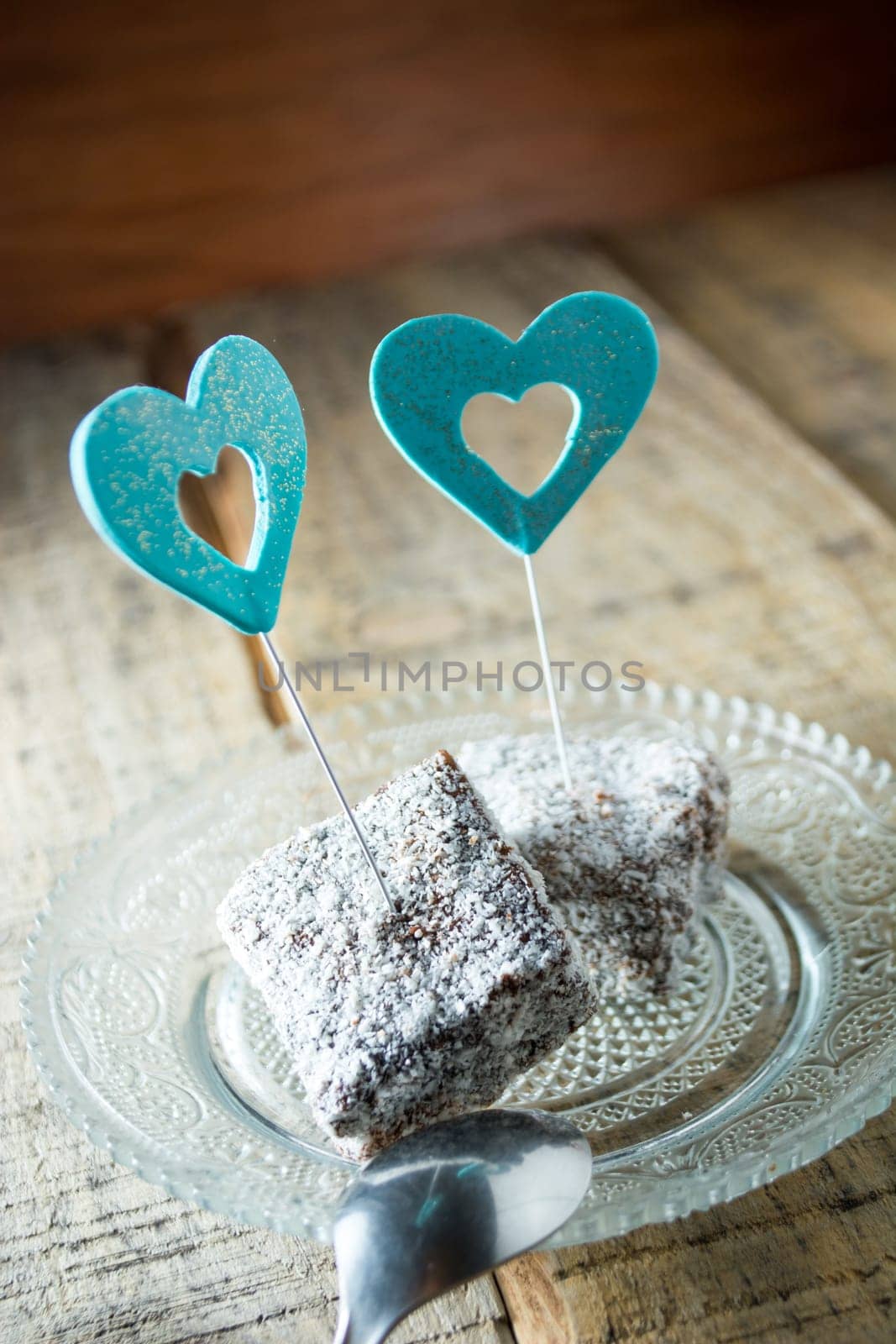 Close up of chocolate cakes with coconut flour on the glass plate with blue ornaments