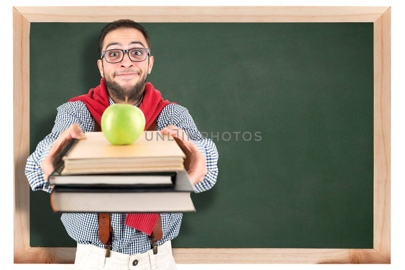 Nerd student posing with books and apple against a chalk board