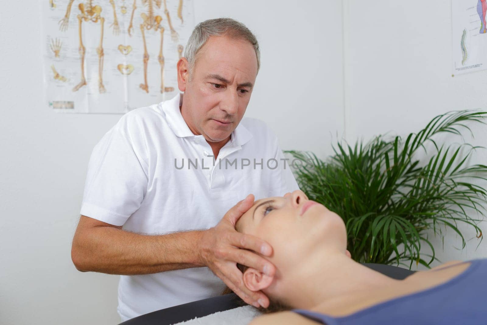 physiotherapist massages holding male clients head