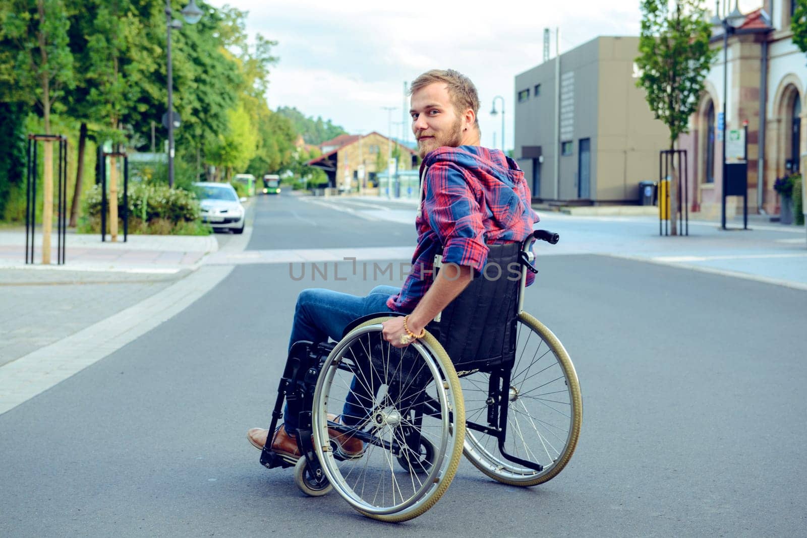 young disabled man in wheelchair on road