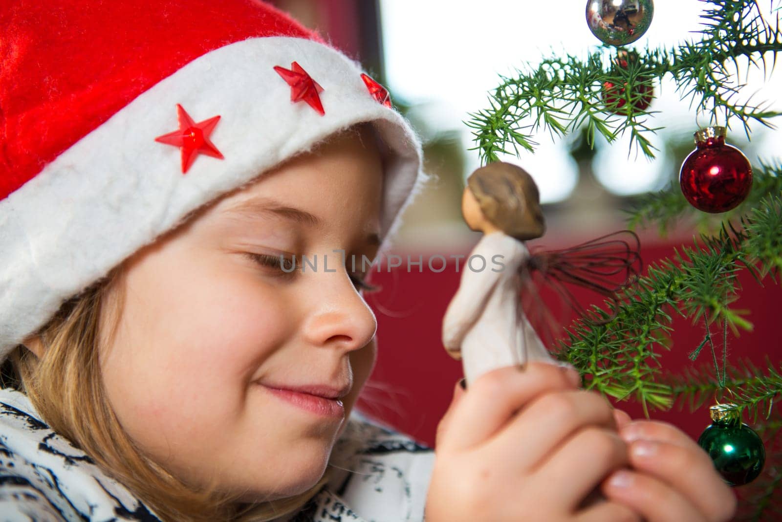 nice girl with Santa- cap and wooden angel