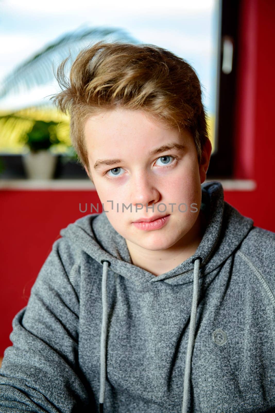 boy with blond hair looking serious in to the camera