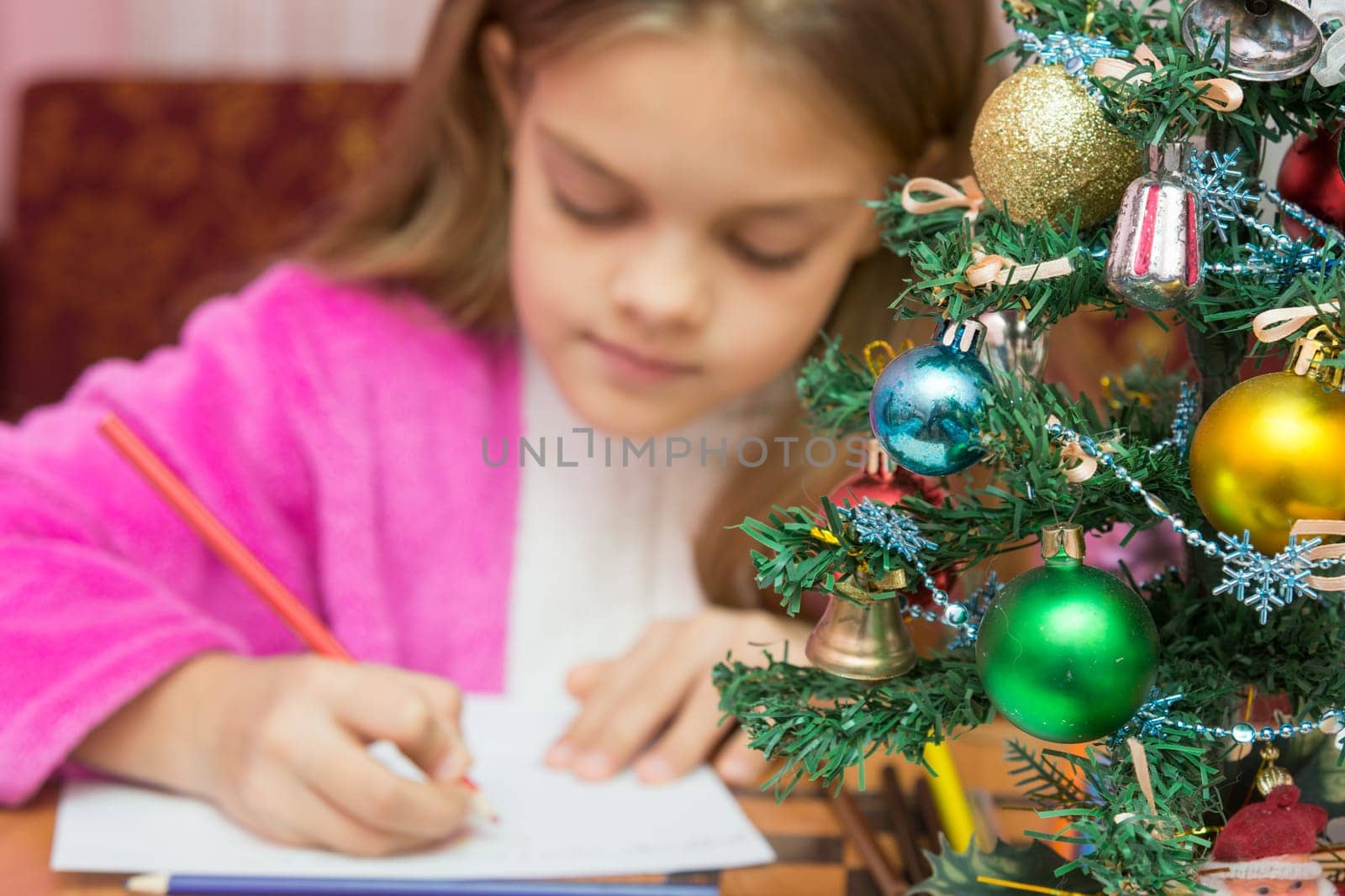 Christmas Tree in the foreground, in the background a girl writing a letter
