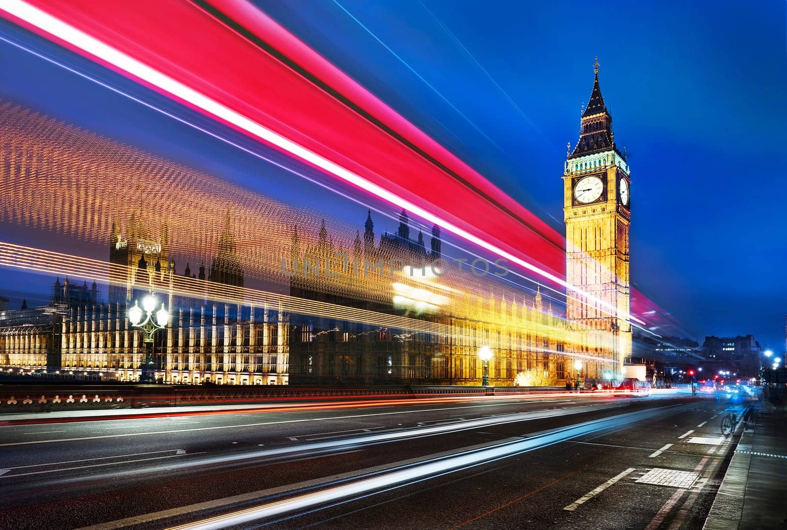 Big Ben, one of the most prominent symbols of both London and England, as shown at night along with the lights of the cars passing