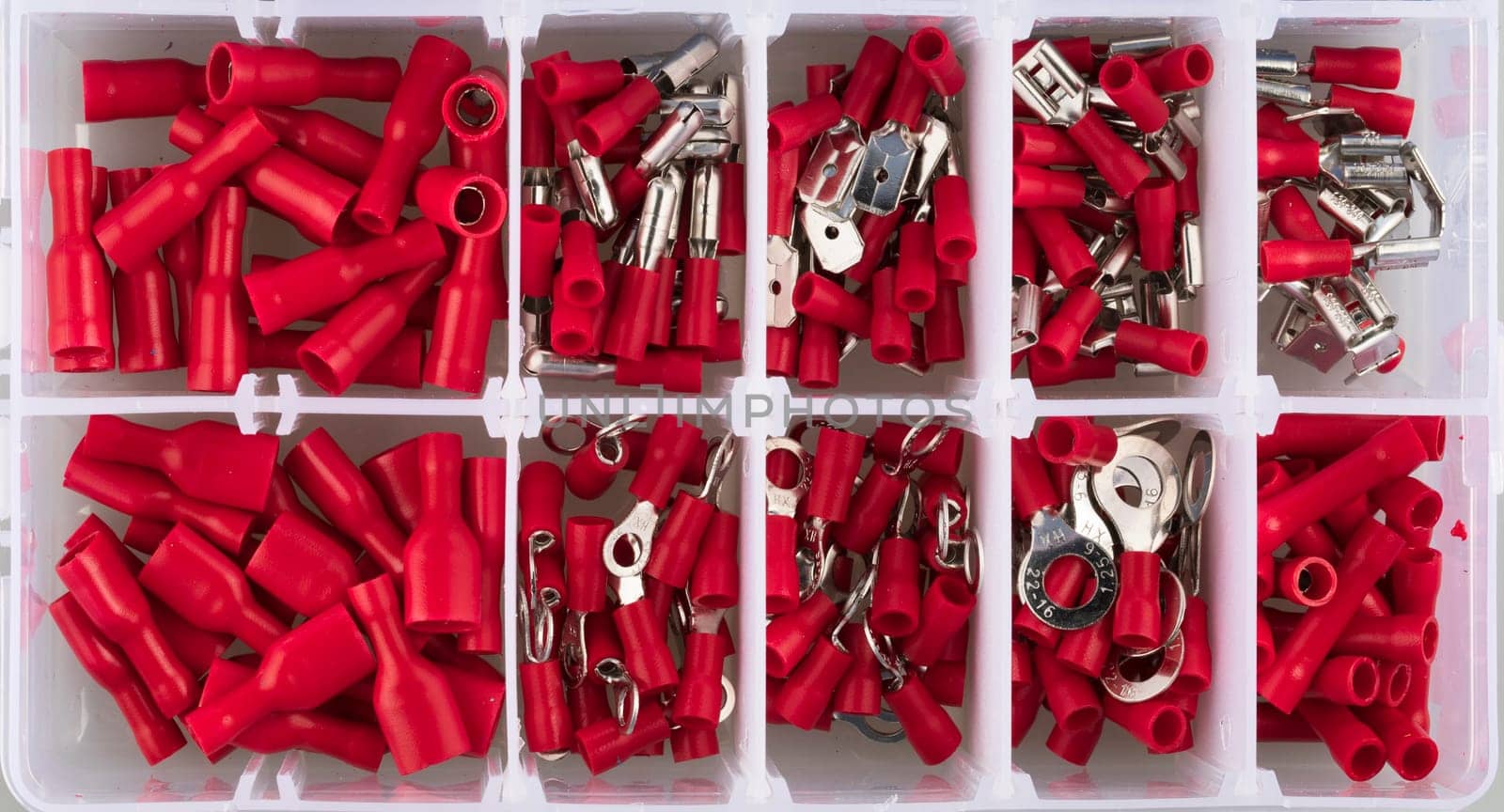 Red electric terminal connectors organized in plastic contaner.