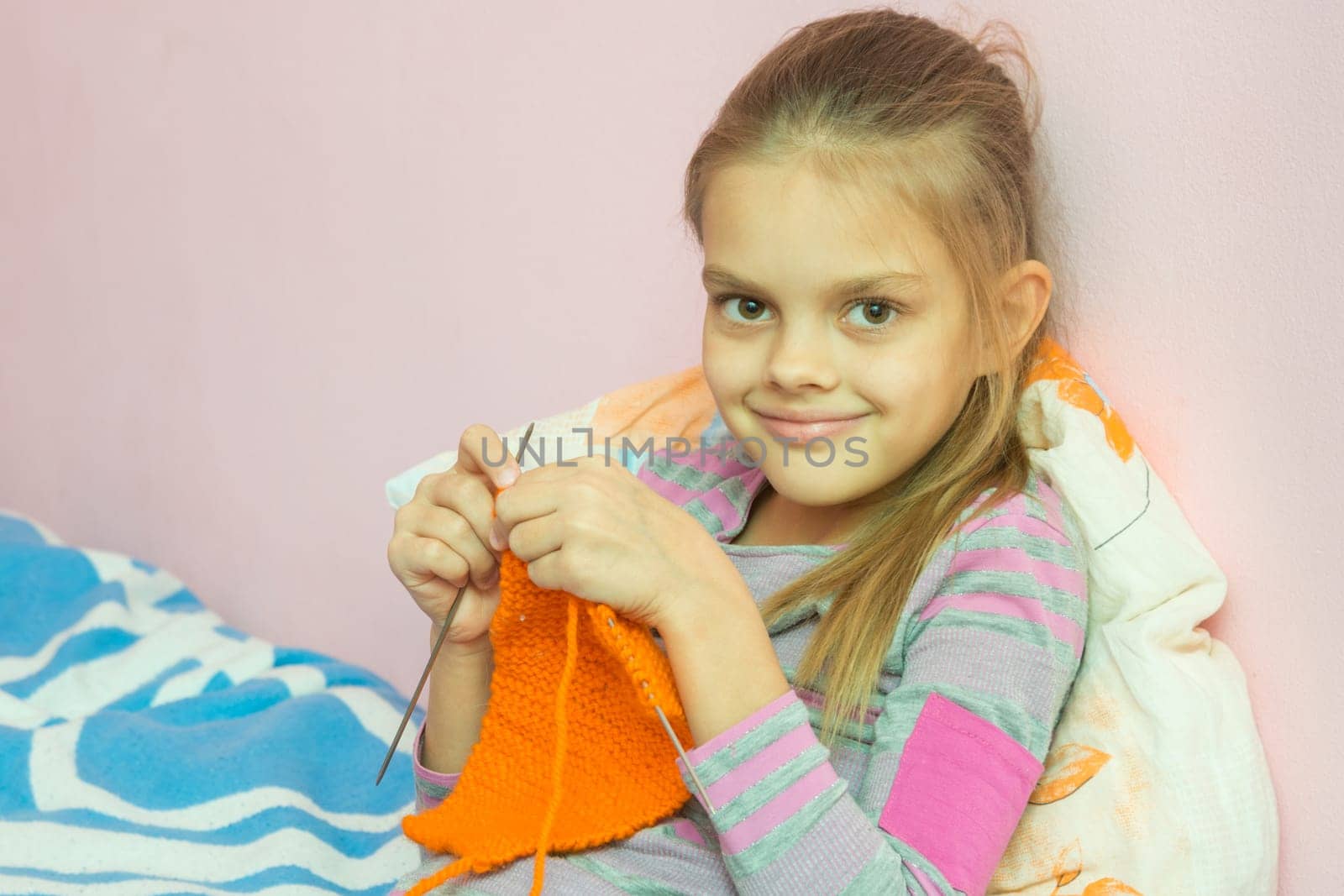 The girl knits on the needles, and looked into the frame