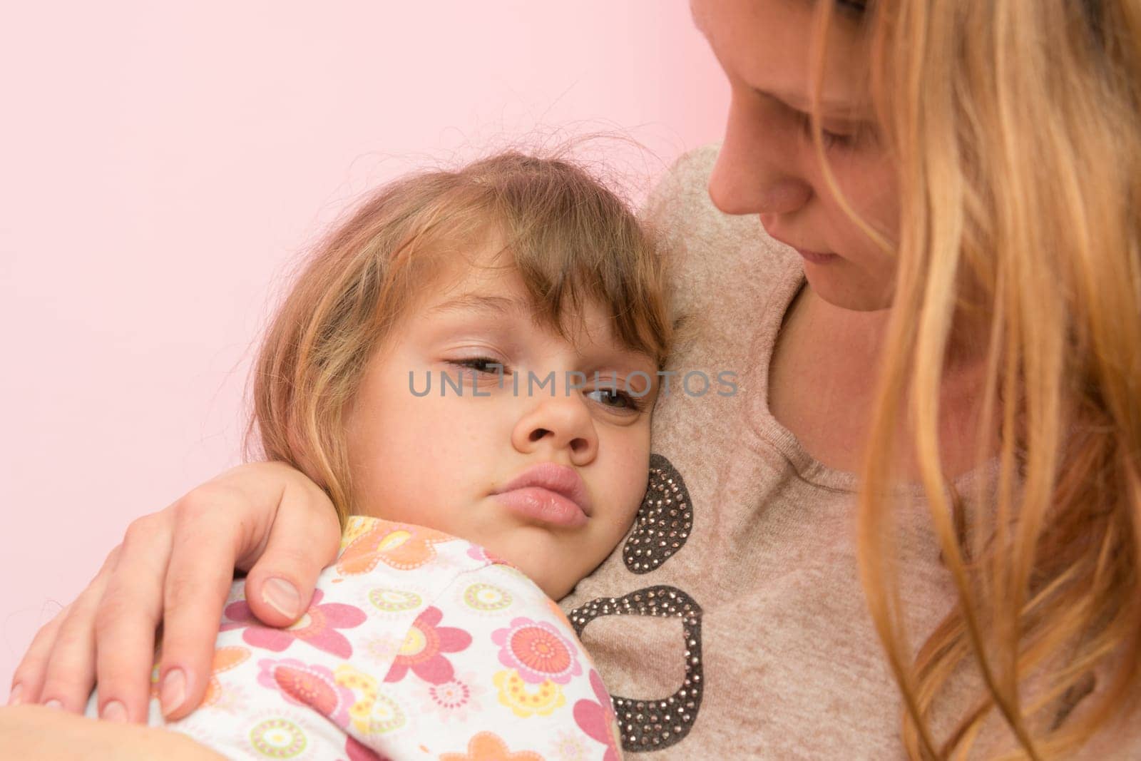 Sad five year old girl clung to her mother