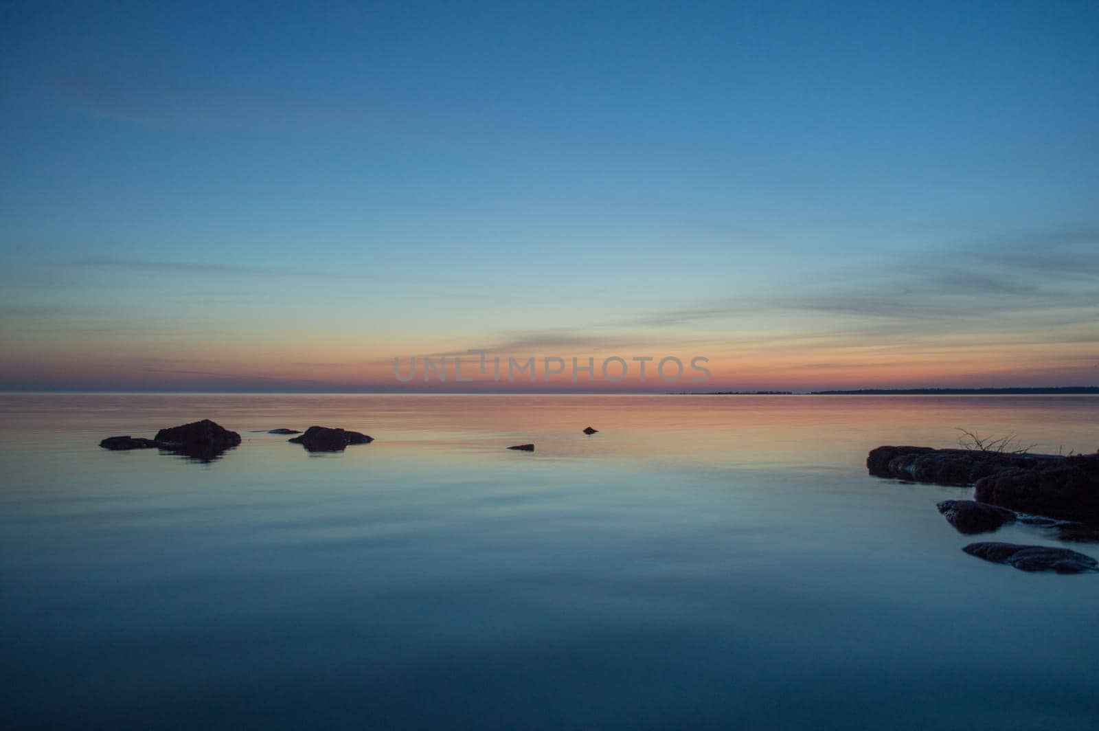 A few small ripples around the rock silhouettes makes this peach and blue image of the water and sky restful