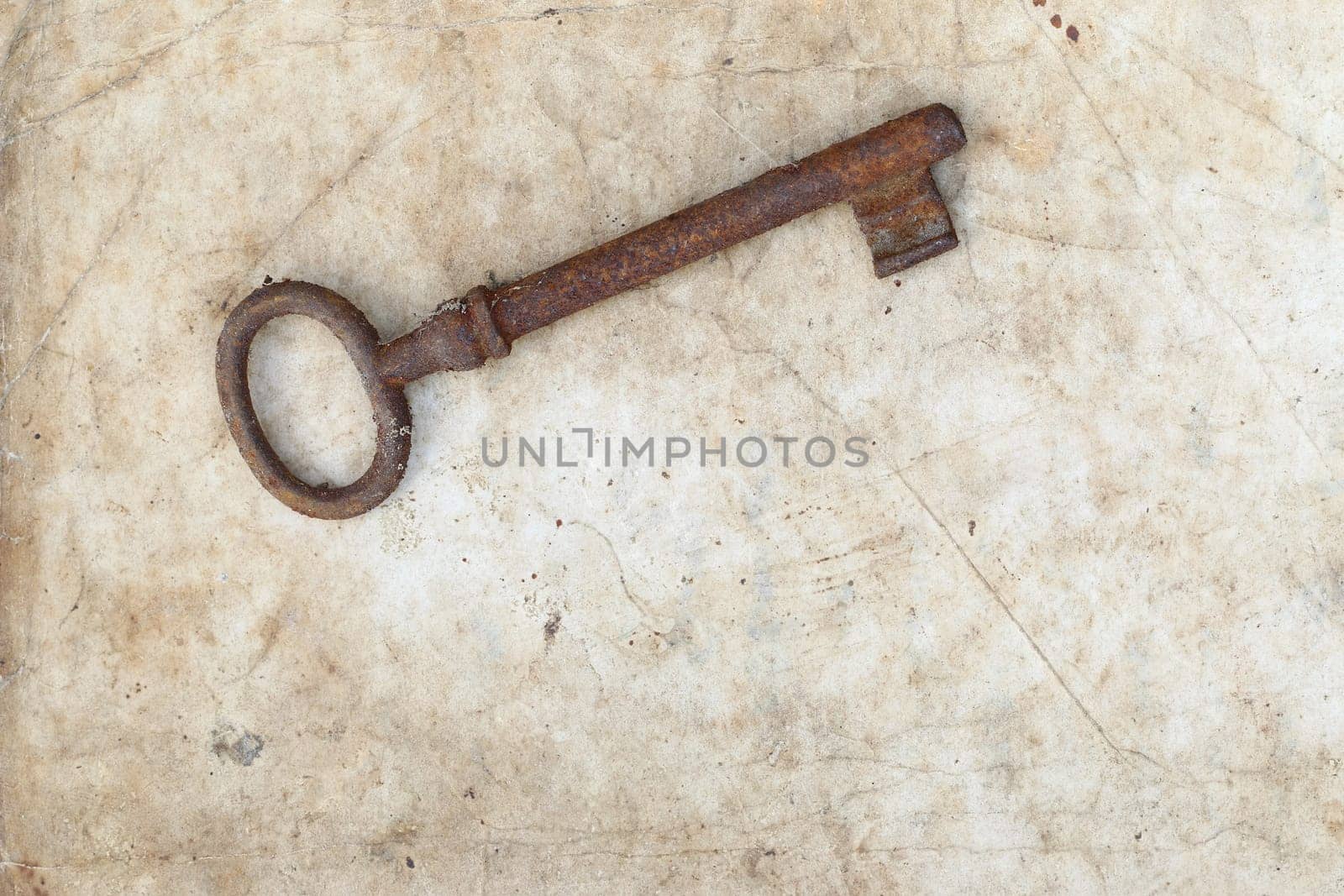Detail of the rusty key on old parchment