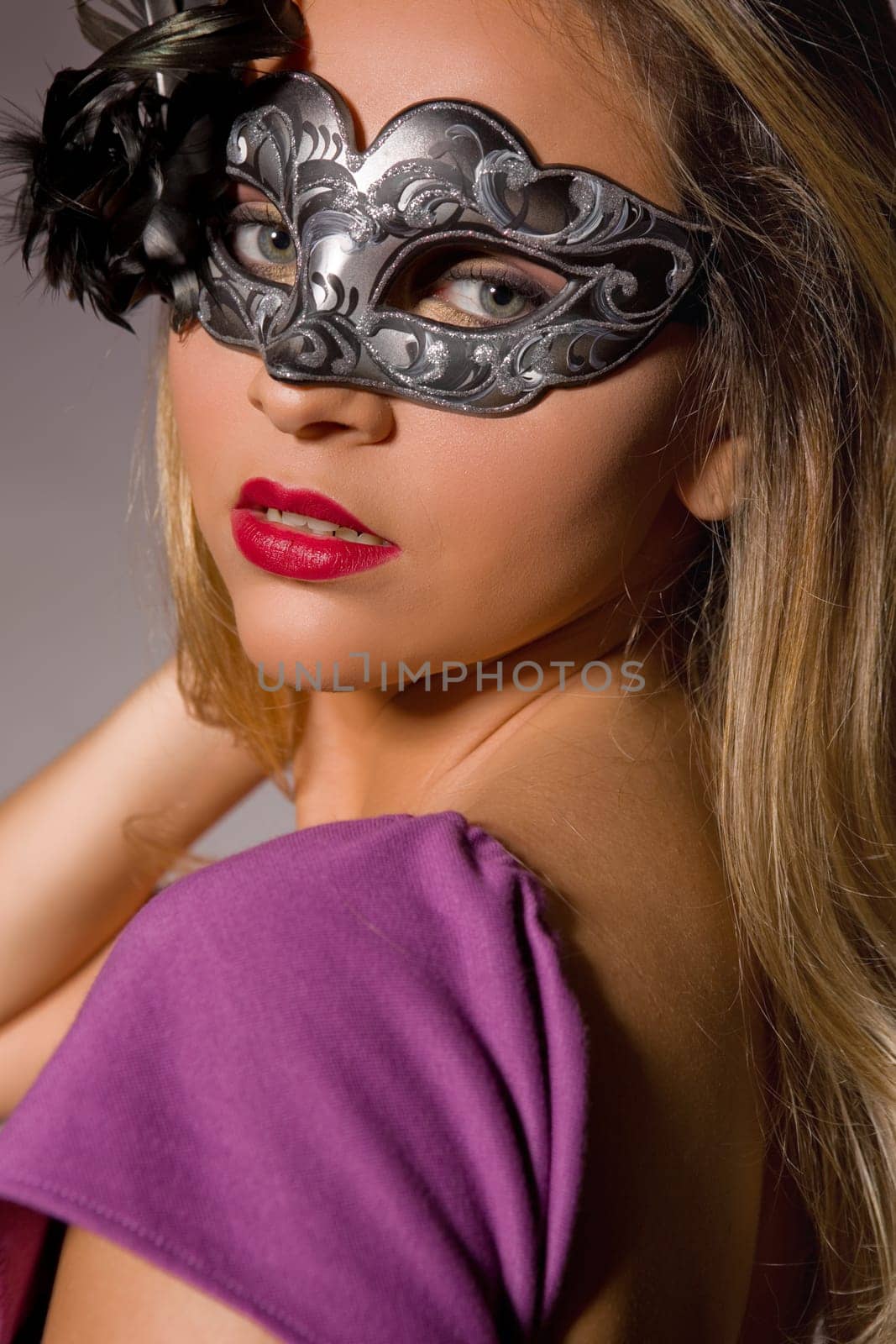 fashion young woman with a mask on a grey background