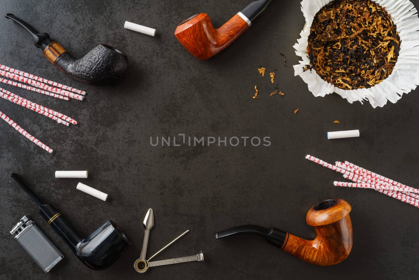 Collection of pipes and smoking utensils with copyspace in the middle
