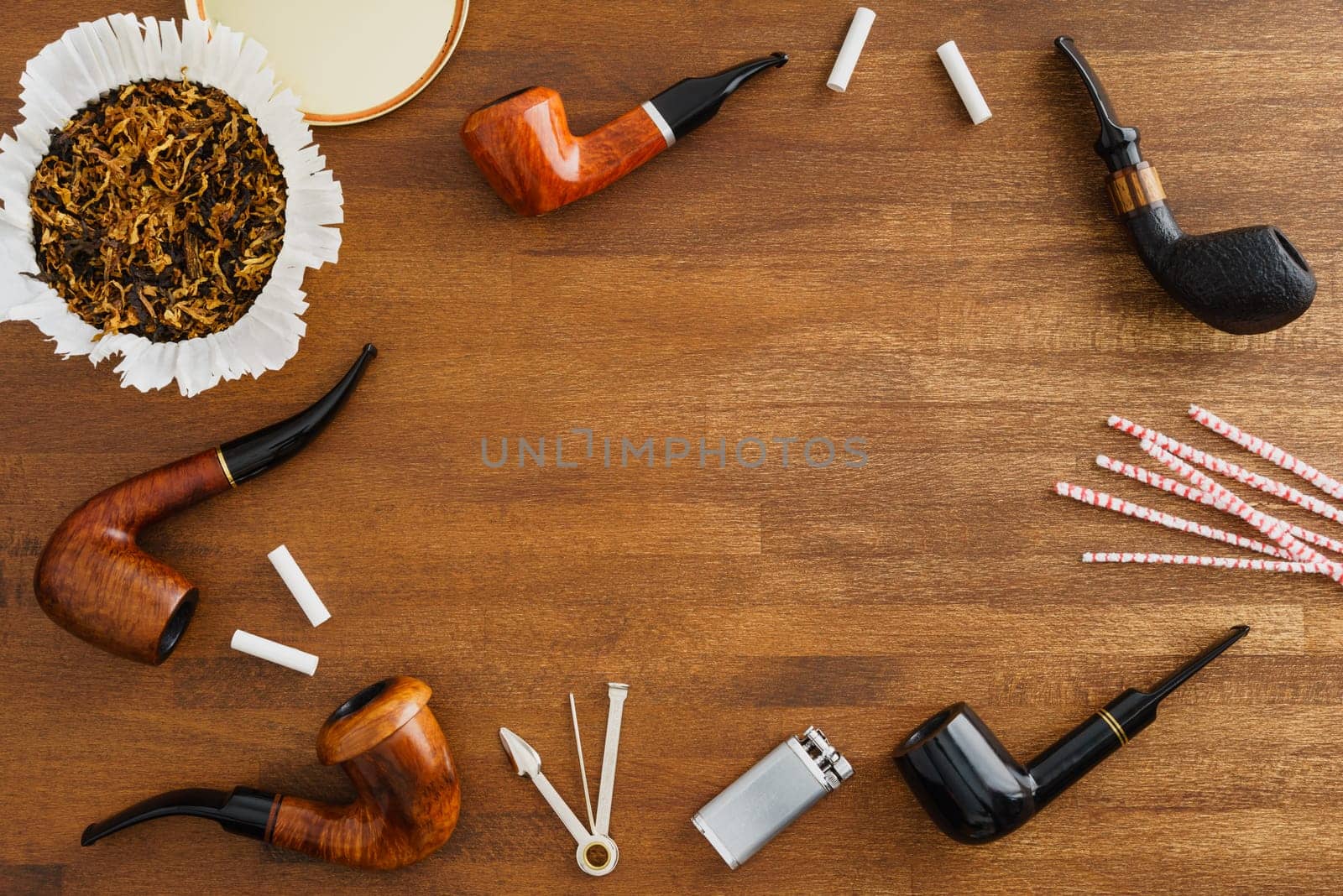 Collection of pipes and smoking utensils with copyspace in the middle