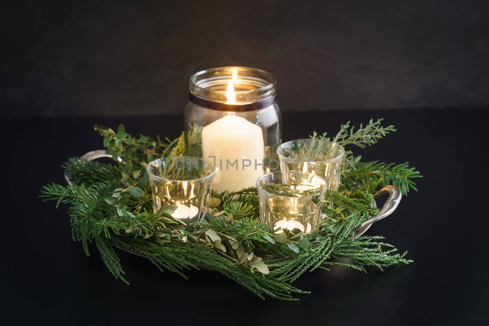 Christmas candle decoration with fir green, conifer, eucalyptus and olive tree branches