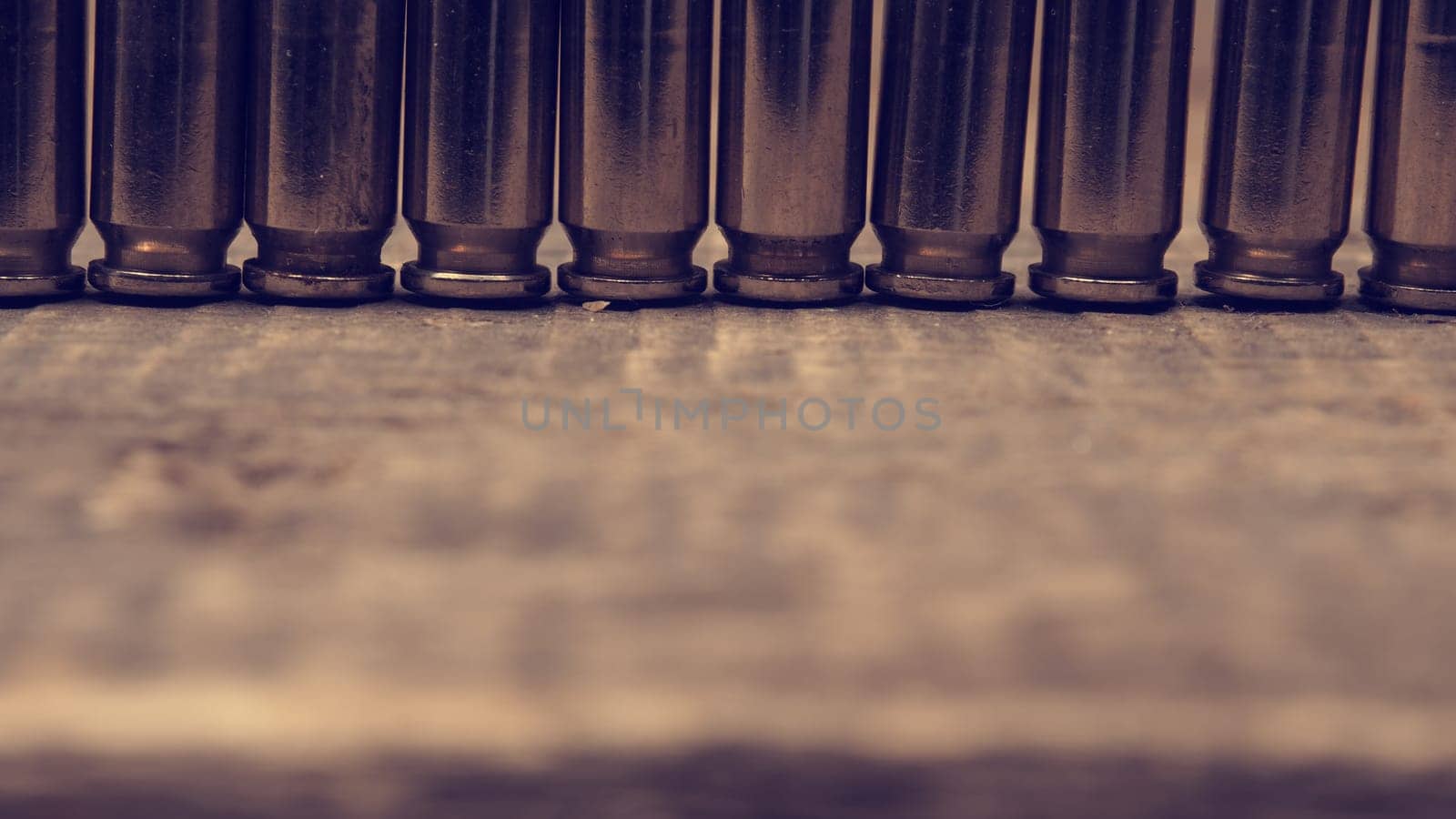 Close up of a row of bullets on a wooden table retro color toned