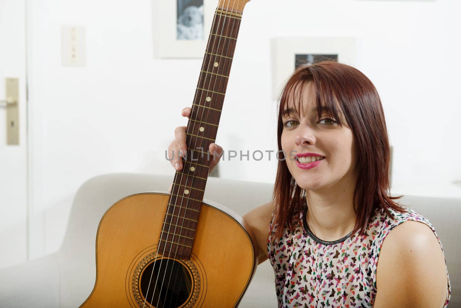 beautiful young woman with acoustic guitar at home