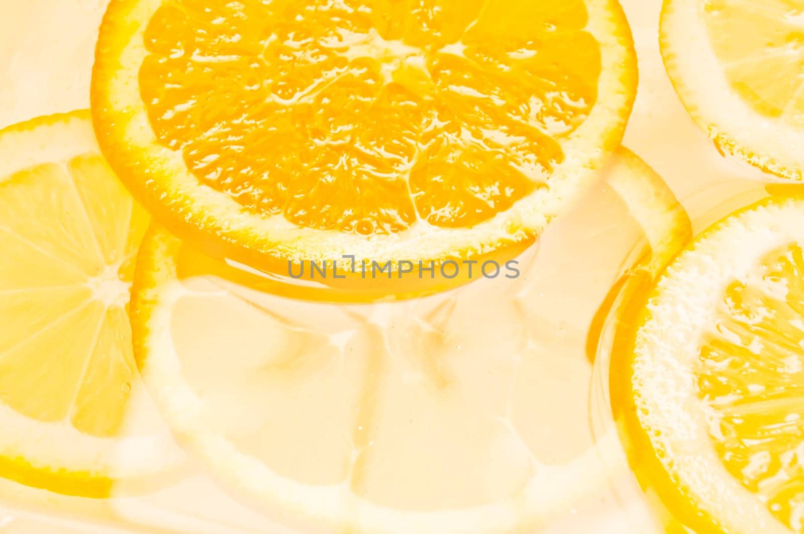 Orange and lemon citrus fruit slices in water with copy space