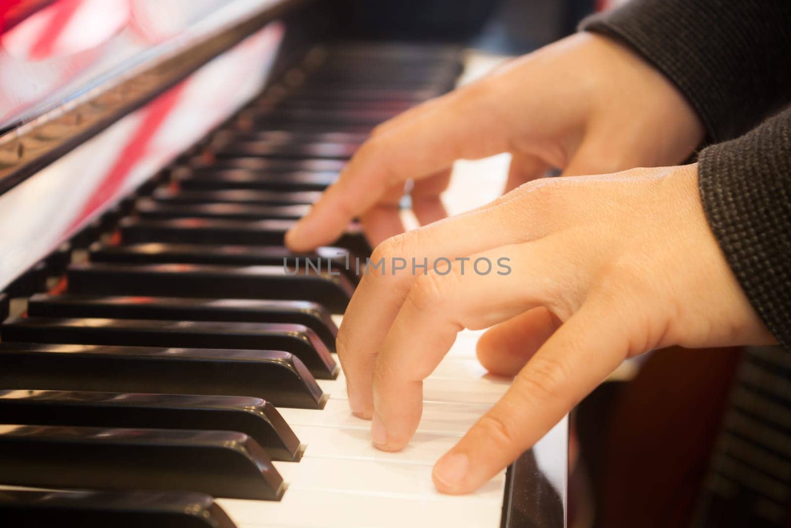 Woman playing on piano keyboard, stock photo