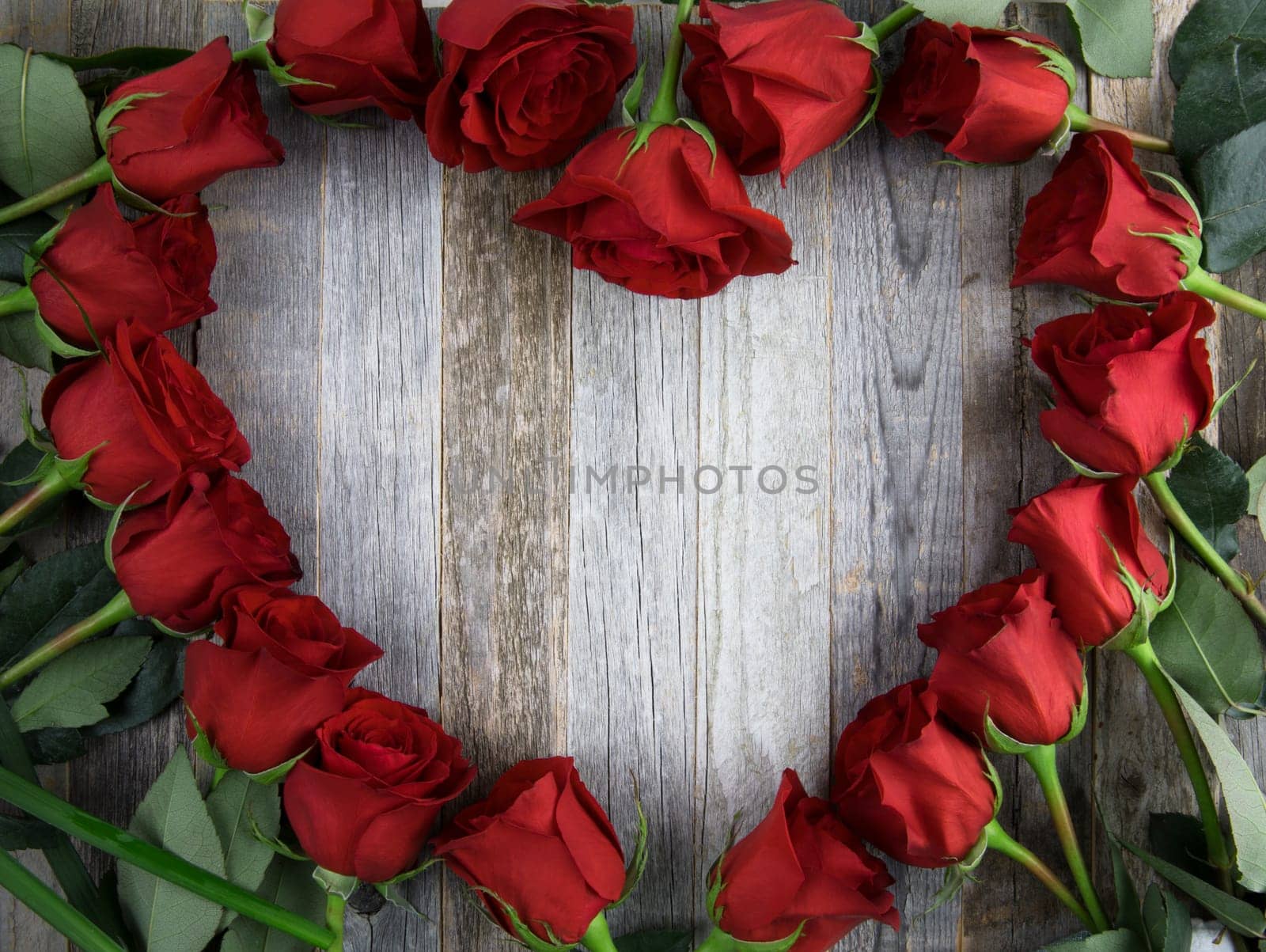 Red rose heart shape frame with copy space on wooden background.