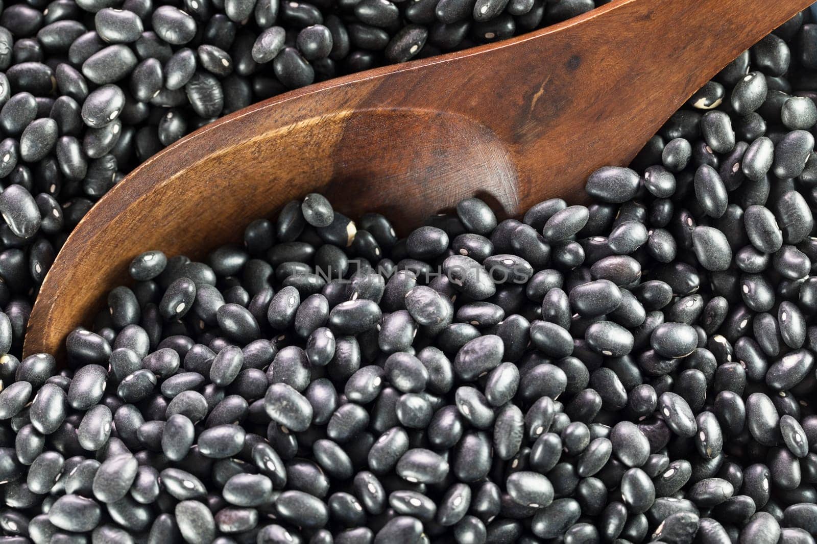 Wooden spoon in dried black beans