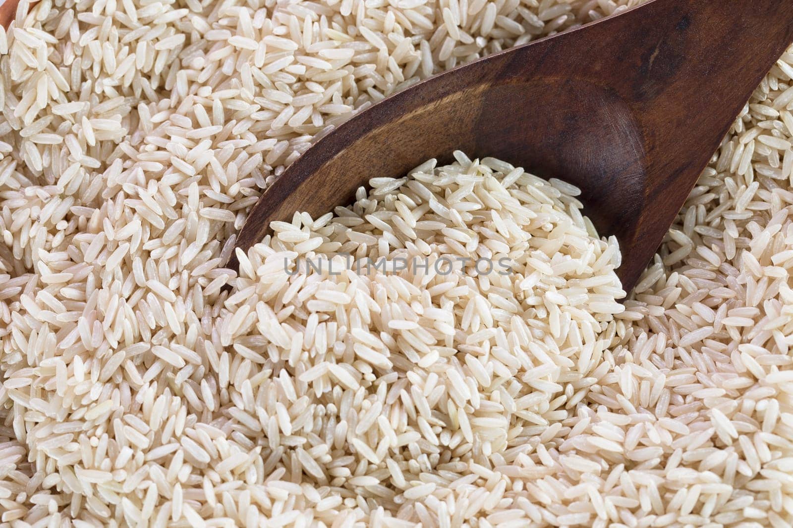 Wooden spoon scooping brown rice