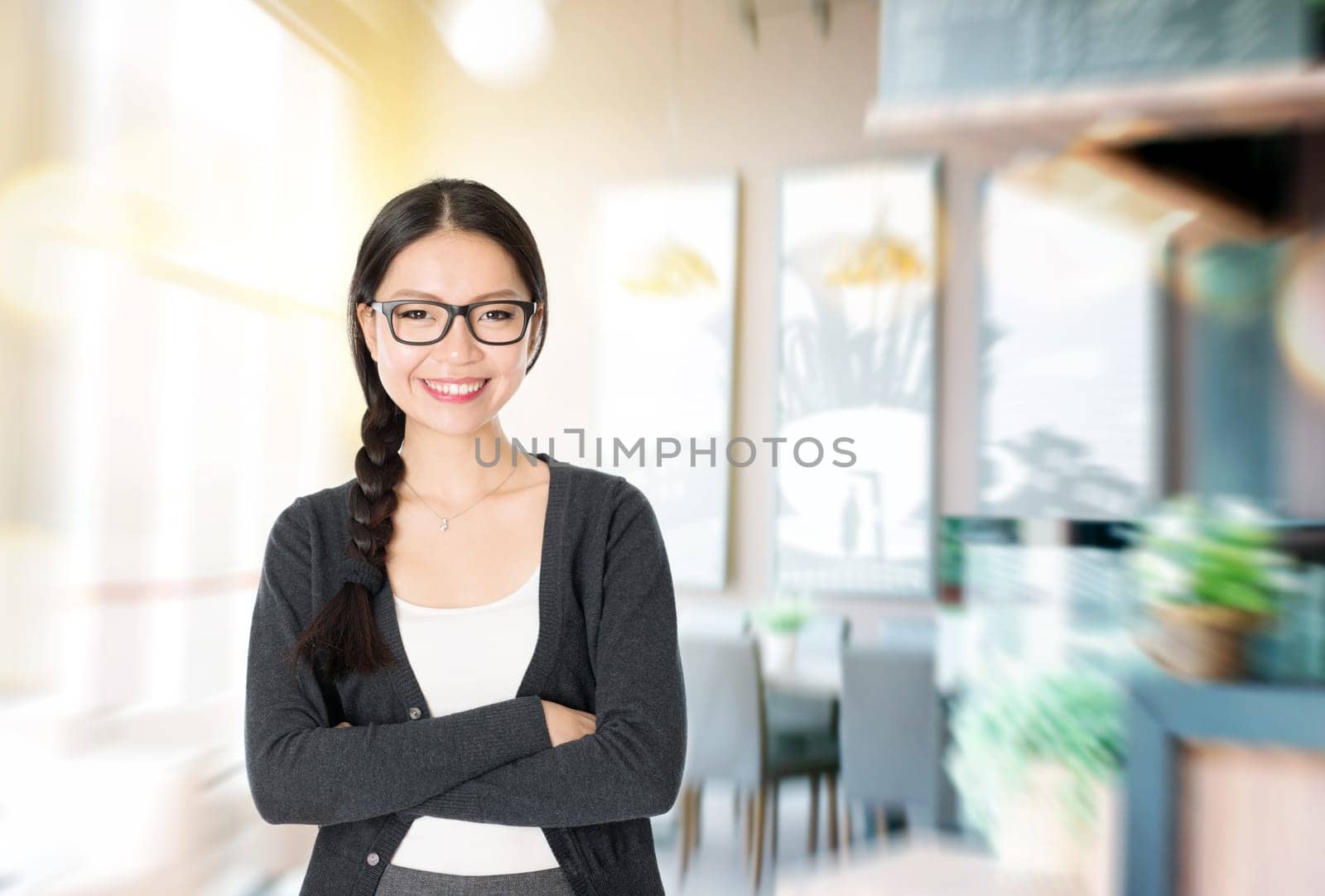 Asian woman arms crossed standing in her cafe. Young female entrepreneur or shop owner.