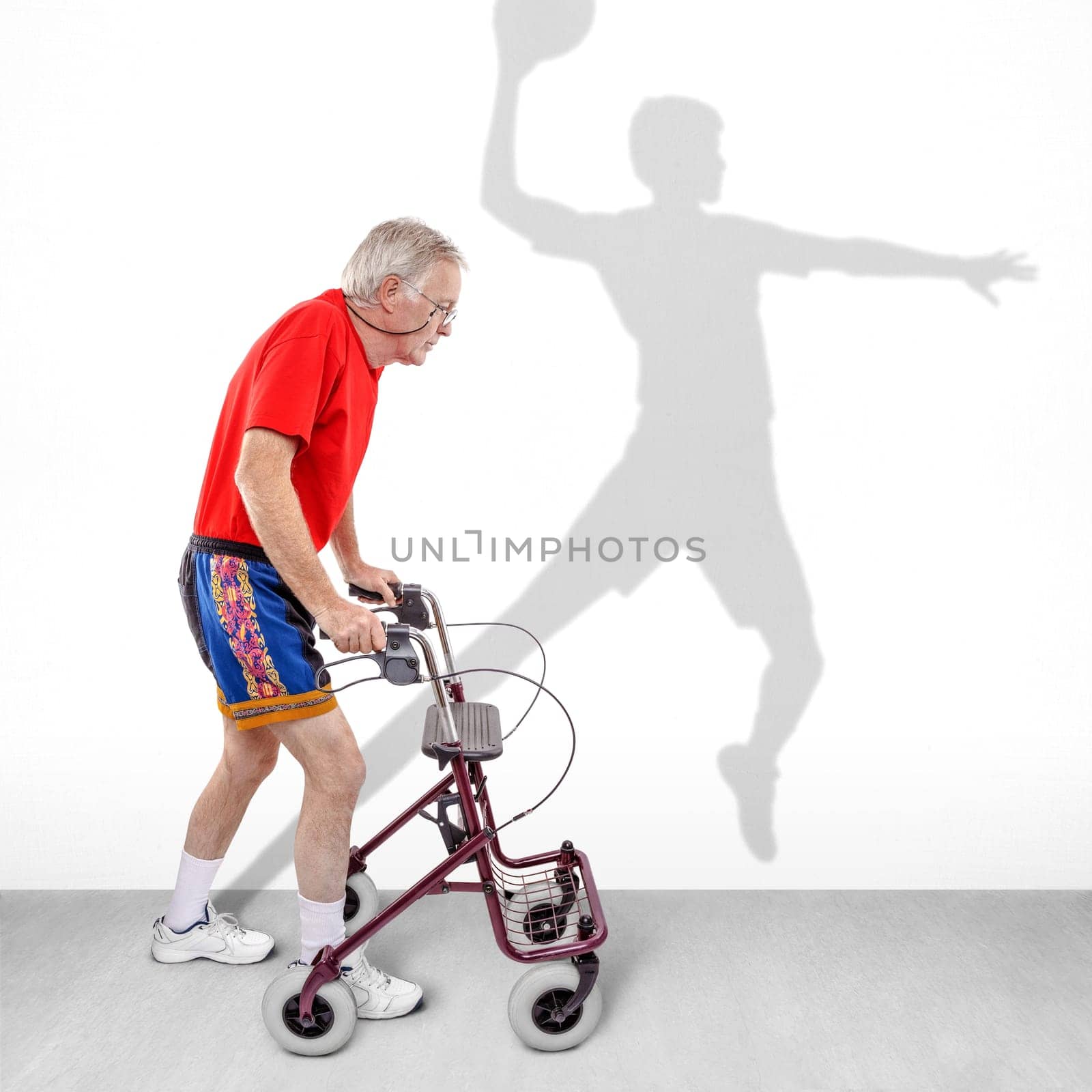 Sick old man walking with a walker along with a shadow of a young athlete on the wall. Concept for youth passing like a shadow or hope for health rehabilitation or recovery motivation.