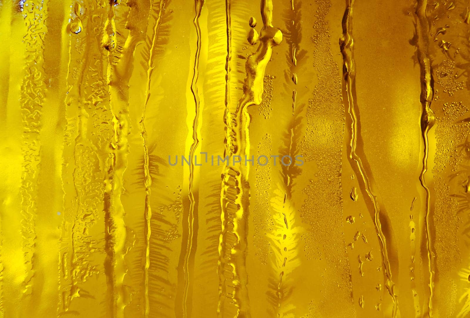 Melted and frosted ice pattern on frosty window glass in winter