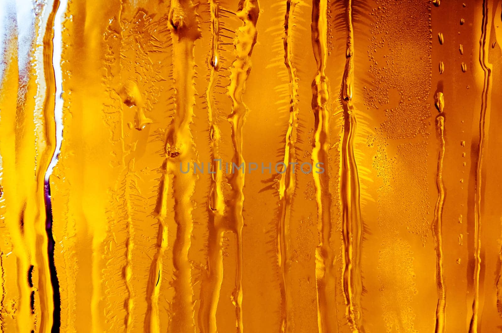 Melted and frosted ice pattern on frosty window glass in winter