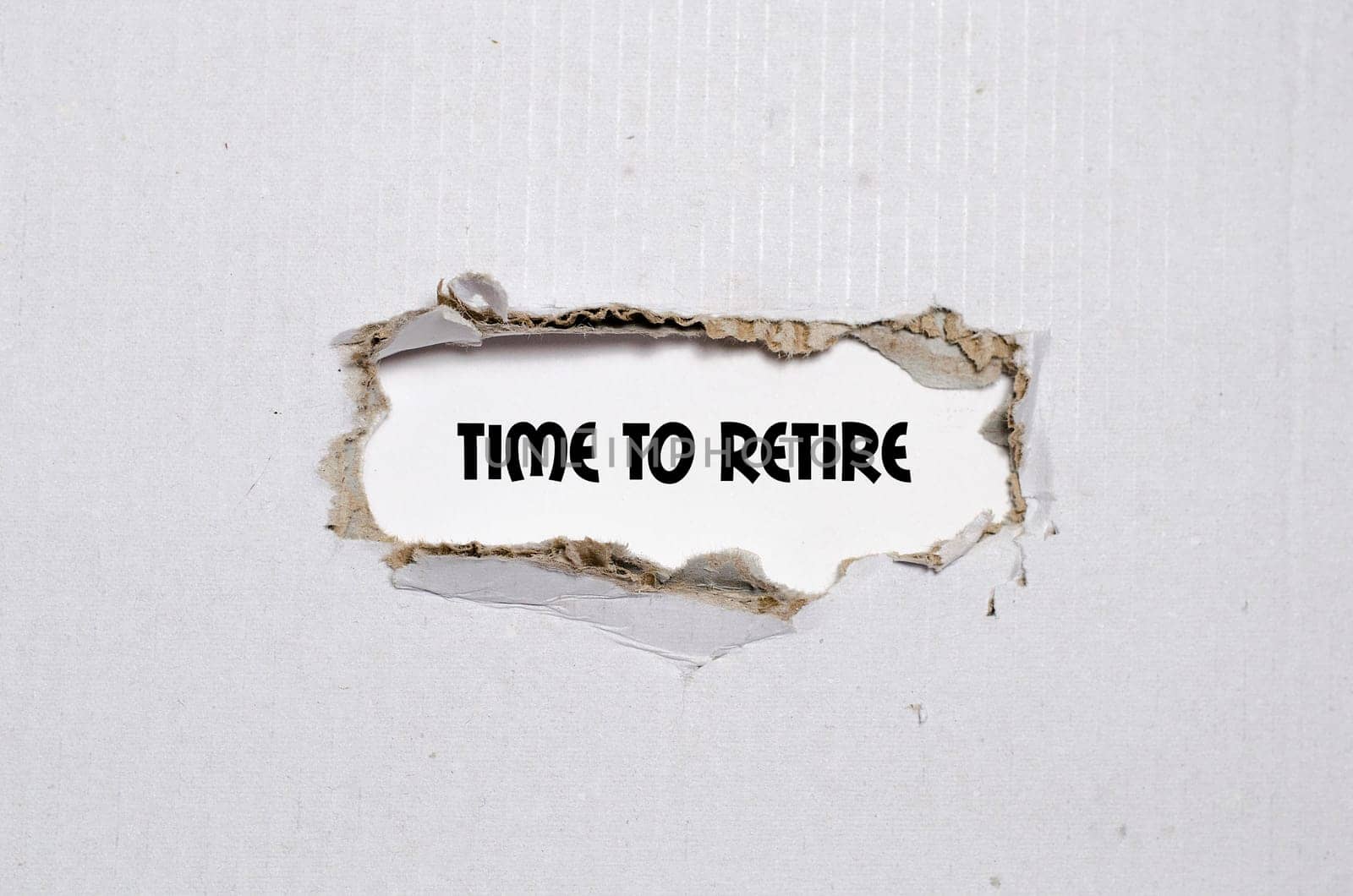 The word time to retire appearing behind torn paper