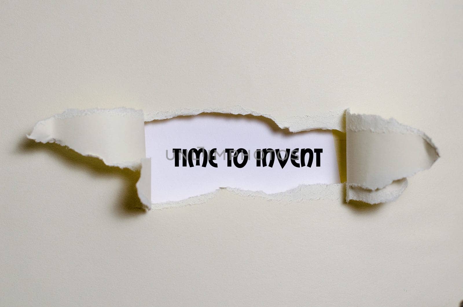 The word time to invent appearing behind torn paper