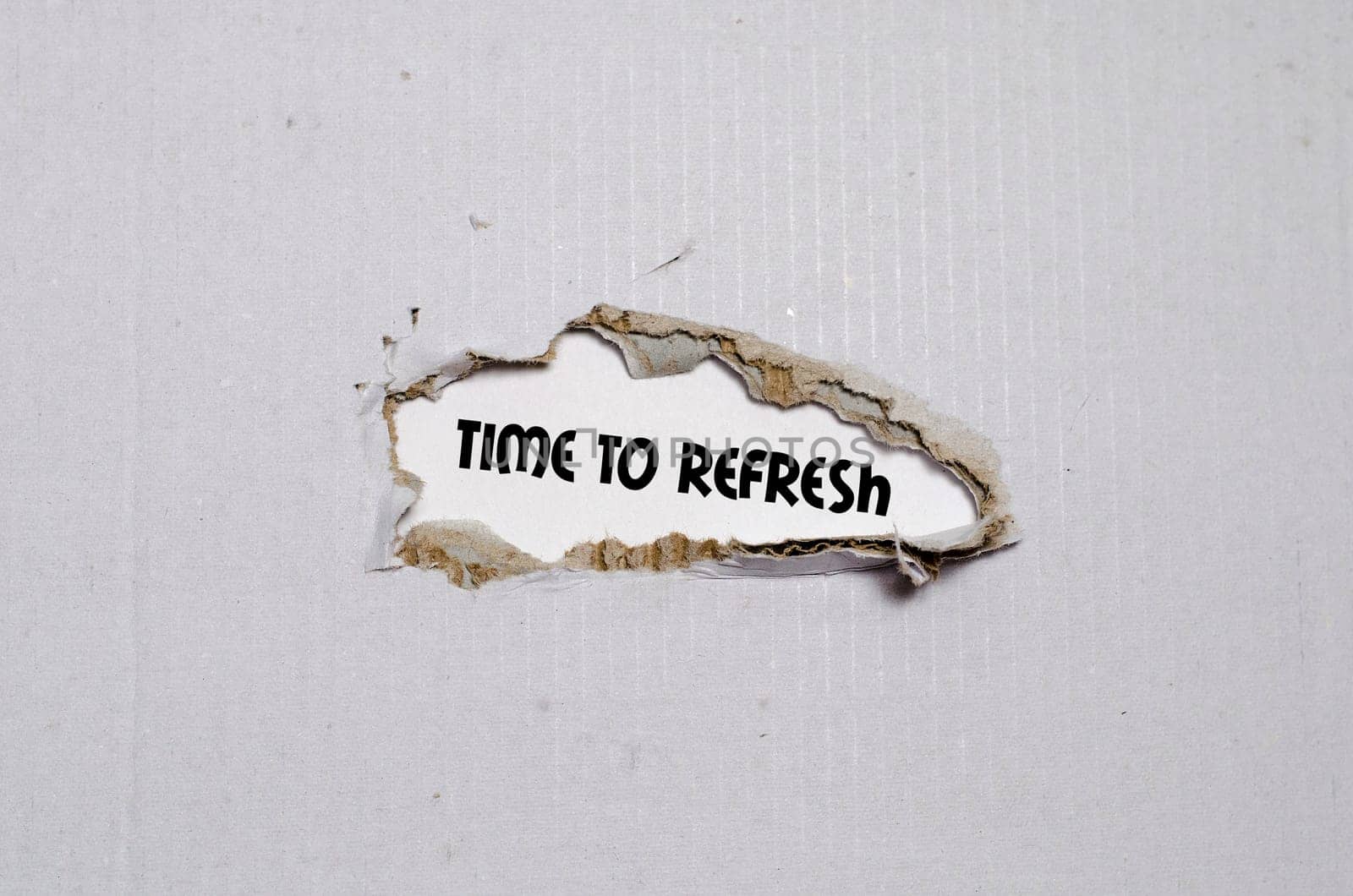 The word time to refresh appearing behind torn paper