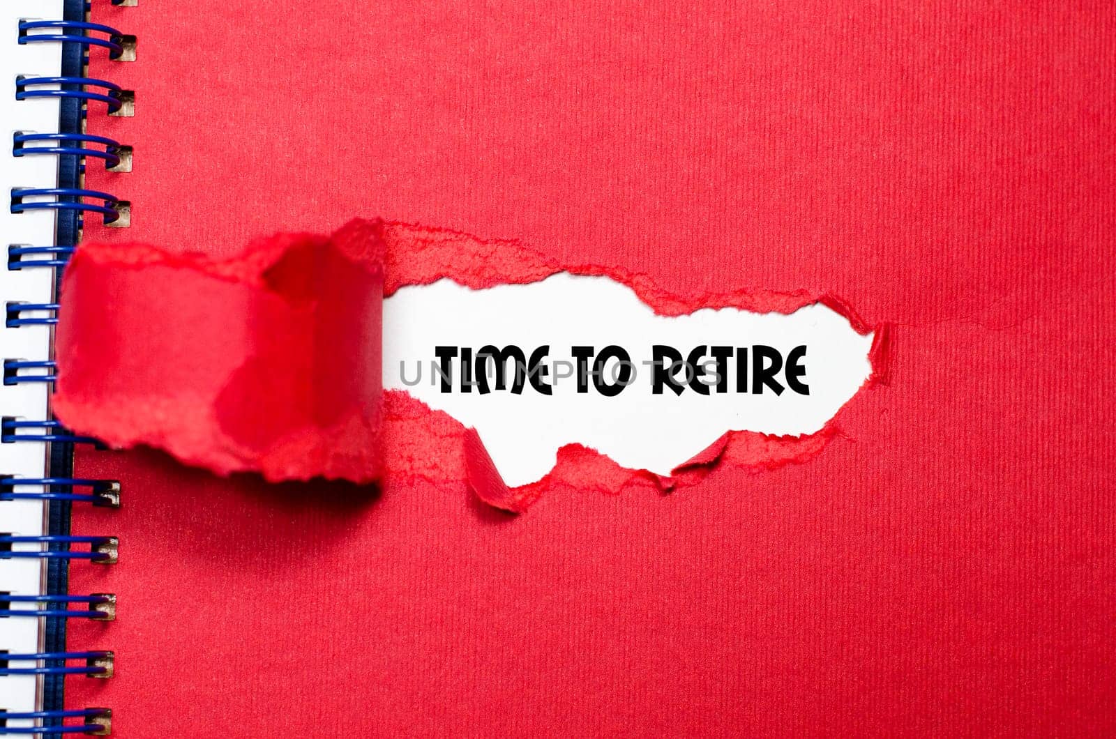 The word time to retire appearing behind torn paper