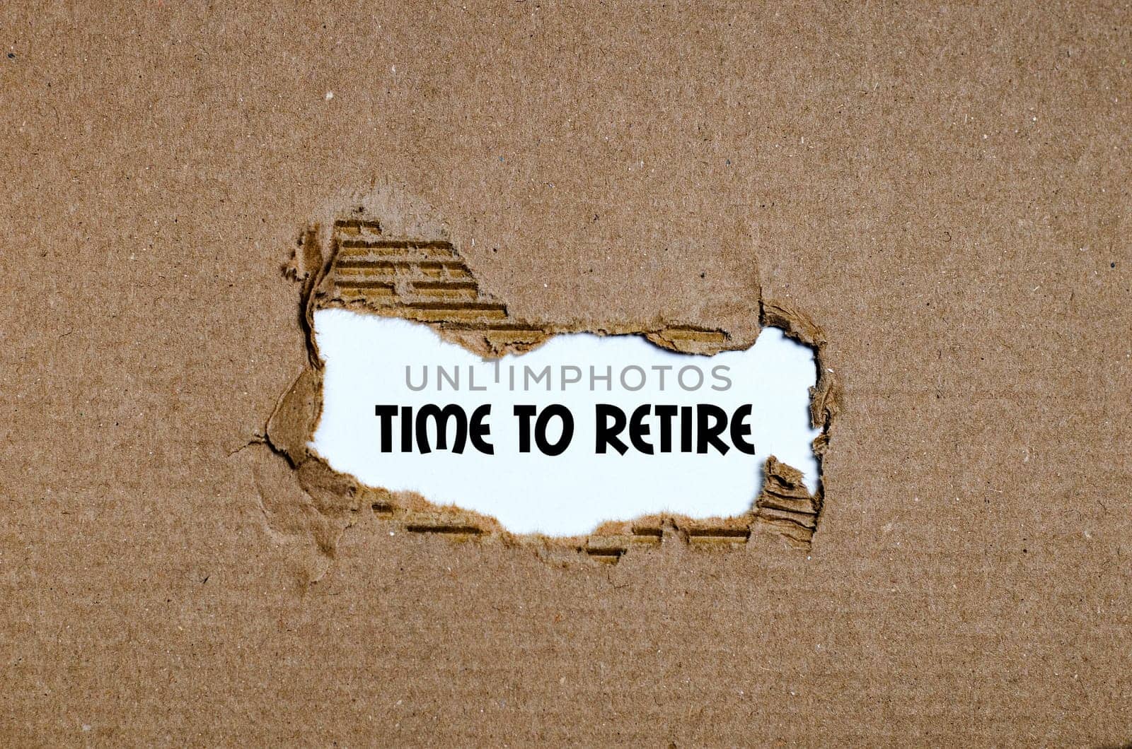 The word time to retire appearing behind torn paper