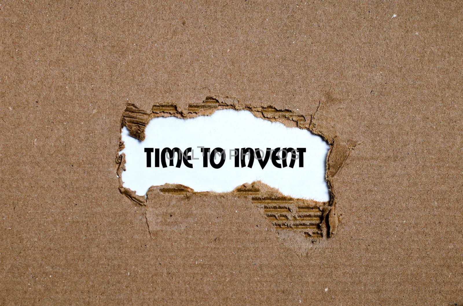 The word time to invent appearing behind torn paper
