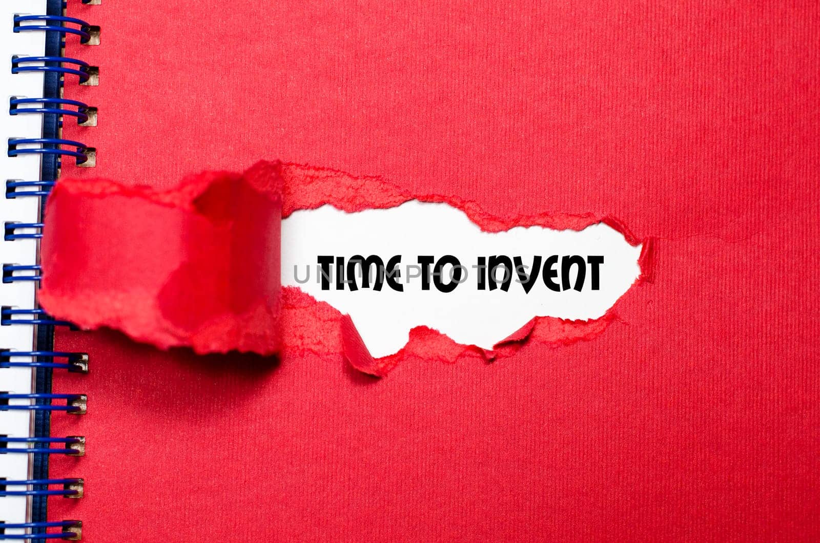 The word time to invent appearing behind torn paper