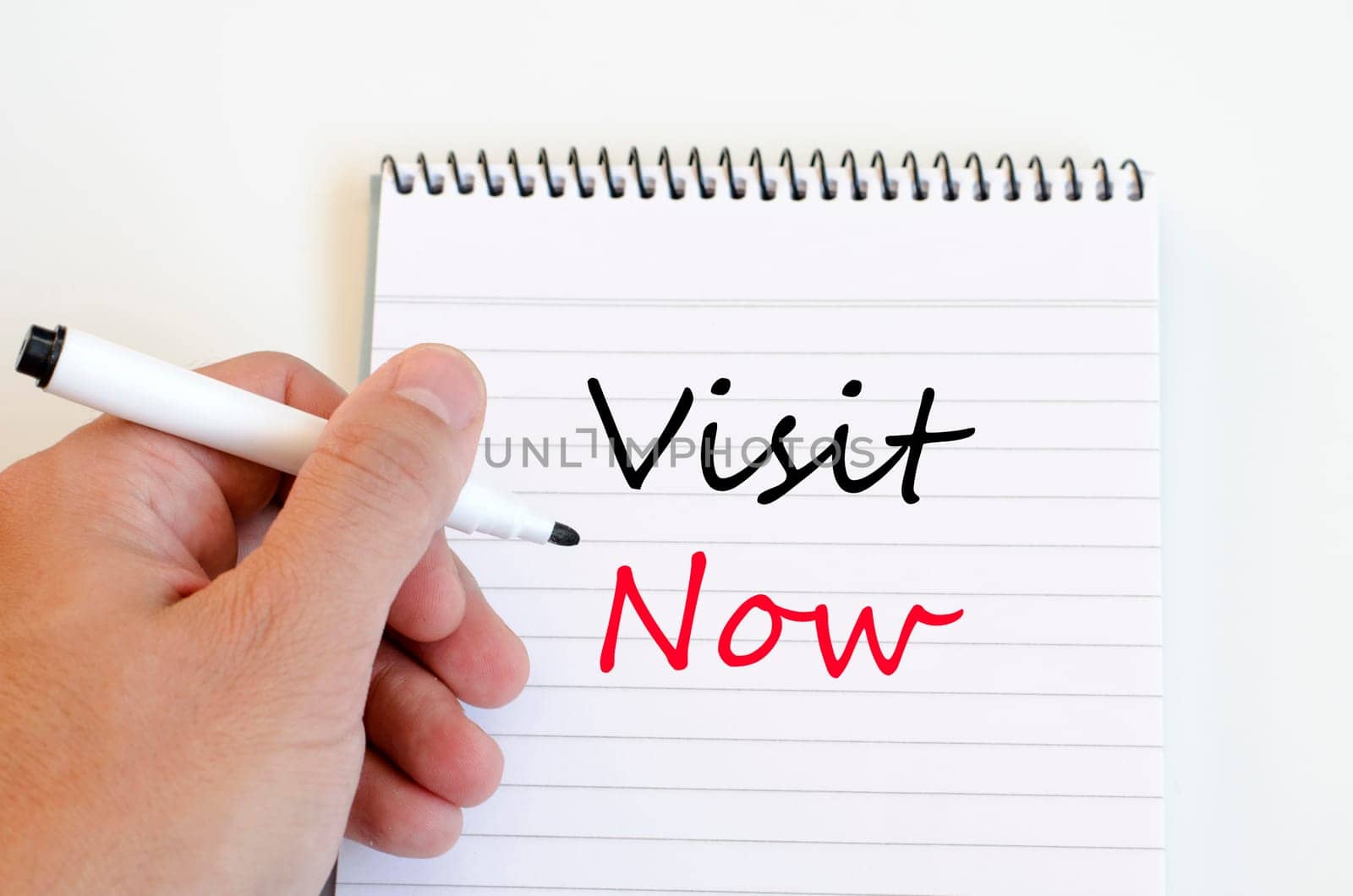Human hand over wooden background and visit now text concept