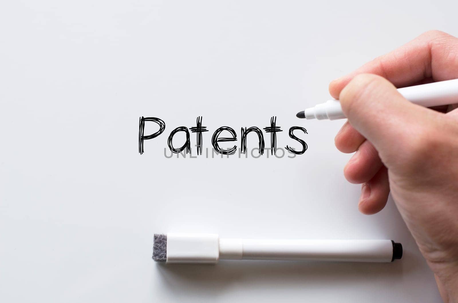 Human hand writing patents on whiteboard