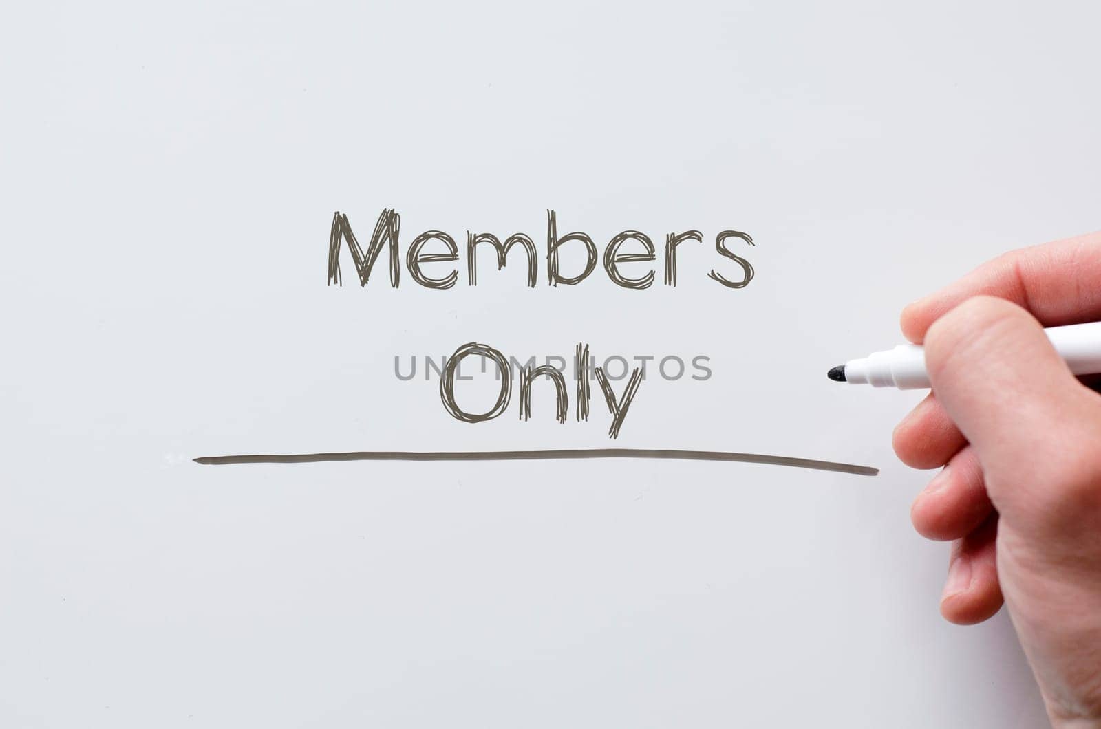 Human hand writing members only on whiteboard
