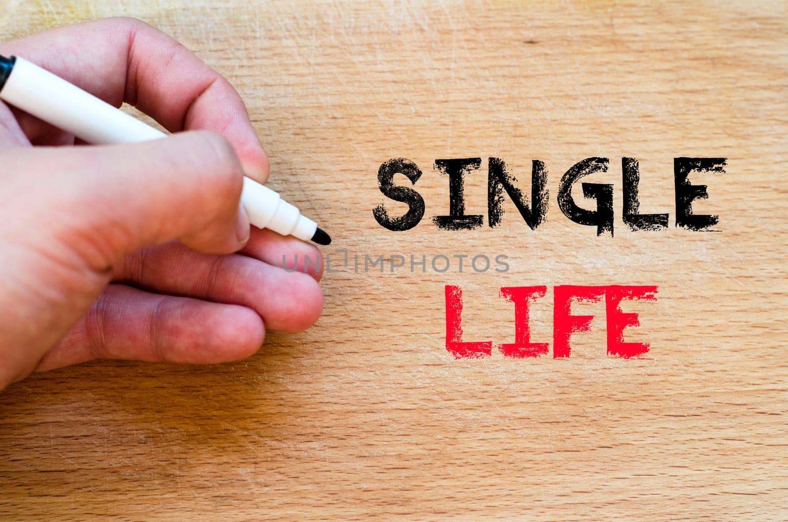 Human hand over wooden background and single life text concept