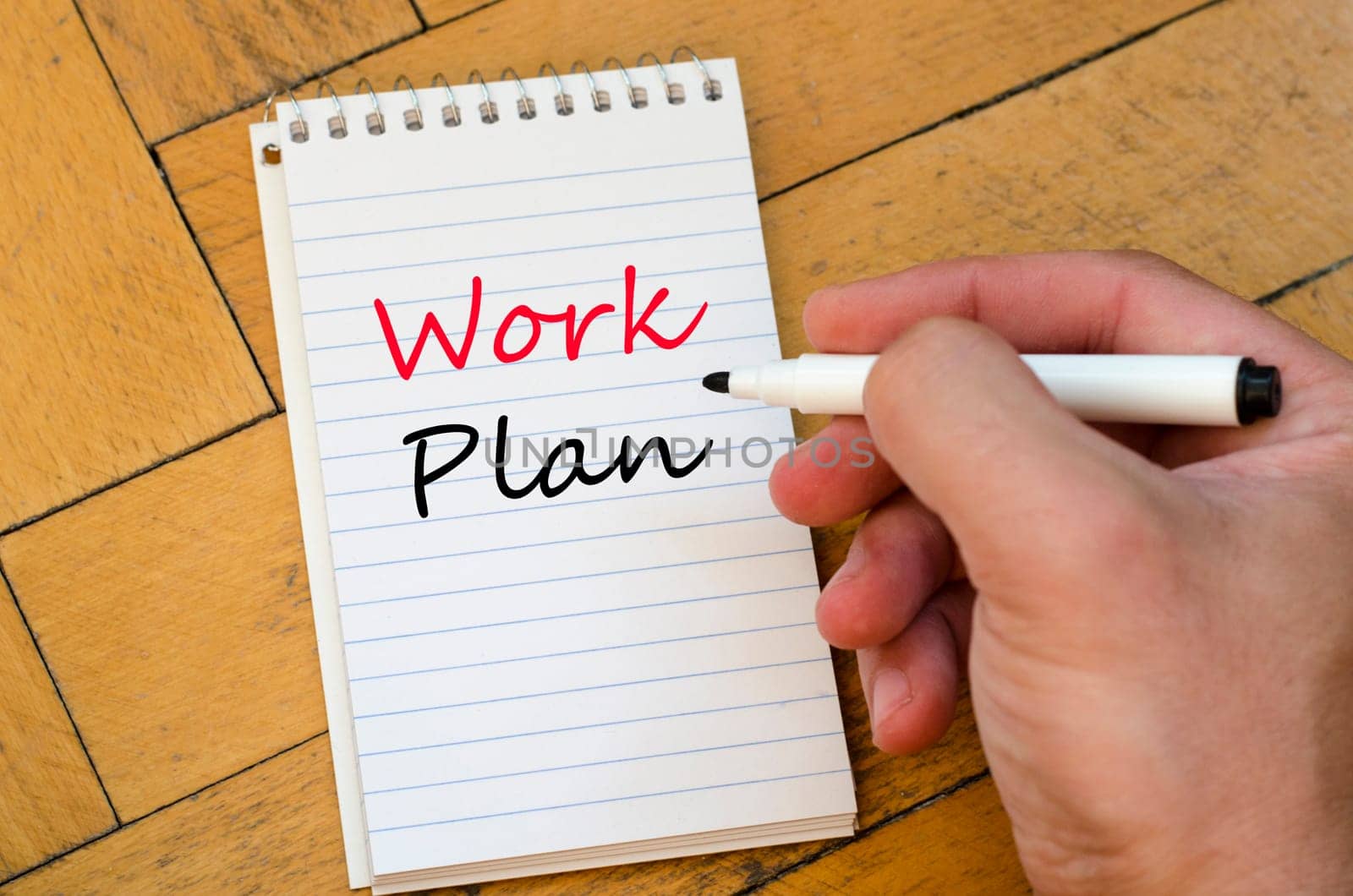 Human hand over wooden background and work plan text concept