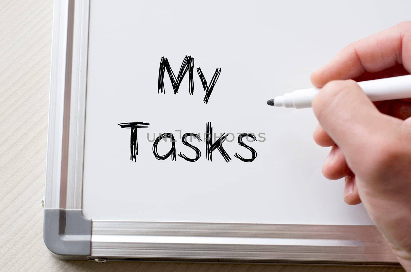 Human hand writing my tasks on whiteboard